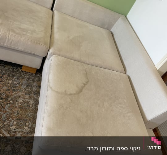ספת בד בהירה עם כתמי נוזלים בולטים לפני ניקוי